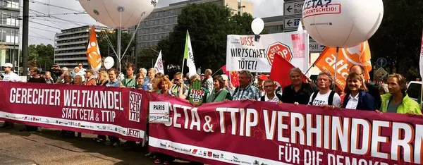 Ein Protestmarsch mit Luftballons und der Aufschrift "TTIP? CETA? Volksentscheid", ist zu sehen.