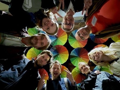 Acht Menschen stehen im Kreis und wurden von unten Fotografiert.