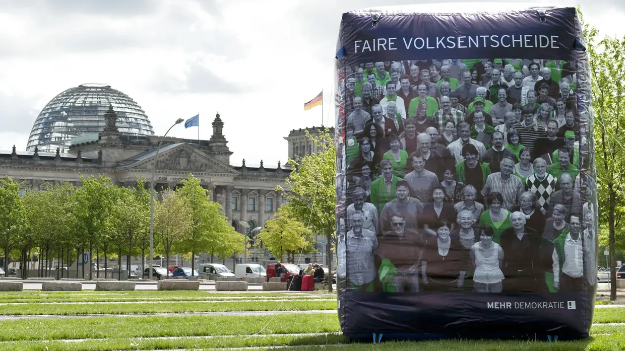 Vor dem Bundestag ist ein circa fünf mal sechs Meter hoher aufgeblasener Plastikwürfel, mit der Aufschrift "FAIRE VOLKSENTSCHEIDE".