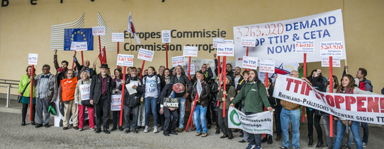 ("Stop TTIP"-Aktion gegen TTIP und CETA vor dem Gebäude der EU-Kommission in Brüssel. | Foto by Alexander Garrido Delgado | Lizenz: CC BY-SA 2.0) Vor dem Gebäude der Europäischen Kommission stehen Demonstranten.