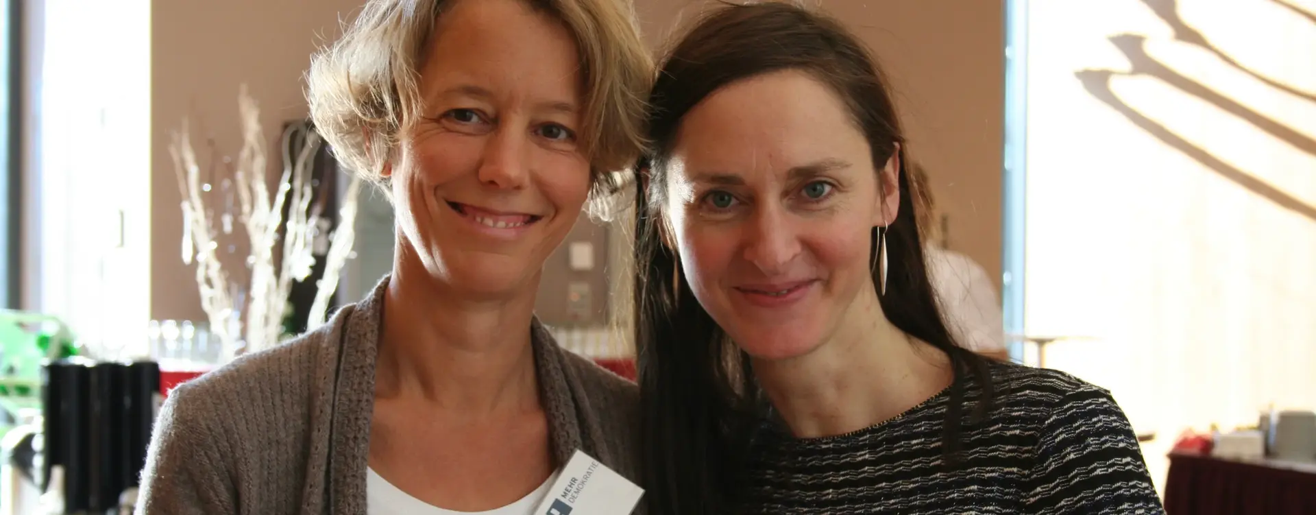 Auf dem Bild sind zwei Frauen, die lächeln.