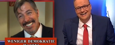 (Auszug aus der ZDF heute show vom 24. Januar 2014) Es ist ein Ausschnitt von der Heute Show zu sehen mit Oliver Welke. Links lächelt ein Mann, mit der Bildunterschrift "WENIGER DEMOKRATIE WAGEN!".