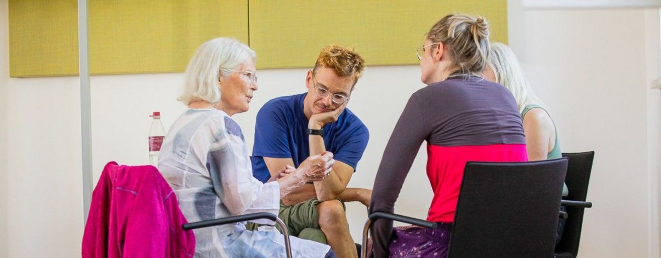 Vier Personen im Stuhlkreis diskutieren