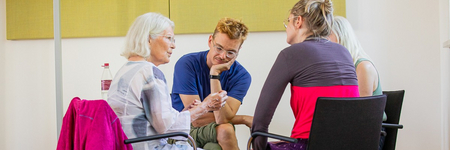 vier Personen sitzen im kreis und sprechen. 