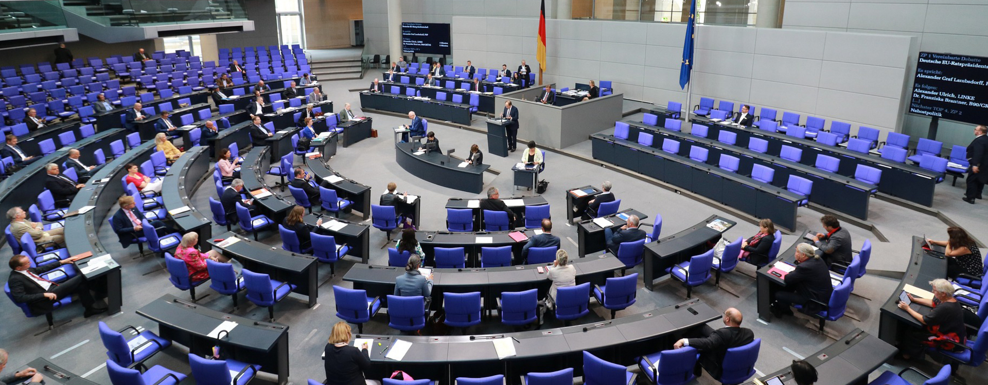 Zu sehen ist der Bundestag von schräg oben, spärlich besetzt. 