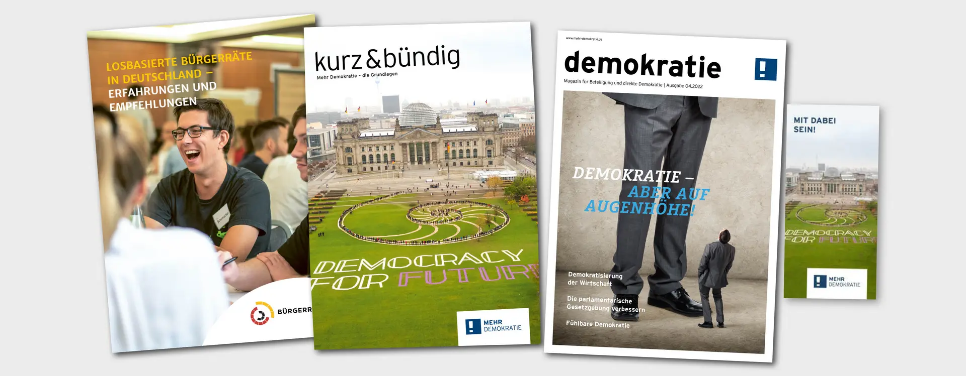 Auf dem Bild sind drei Magazin von Mehr Demokratie abgebildet und ein Flyer.