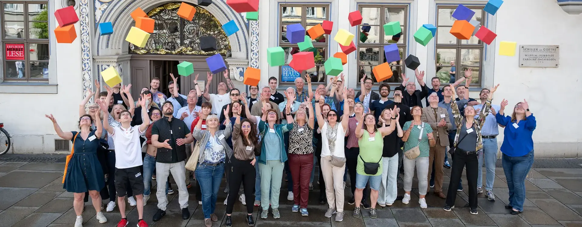 Circa 40 Menschen schmeißen farbige Boxen in die Luft.