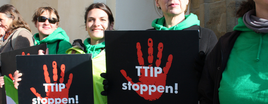 (Foto by Cornelia Reetz | Lizenz: CC BY-SA 2.0) Ein Protest gegen TTIP Mit schildern "TTIP stoppen!" und "Fracking? Nein, danke!" ist zu sehen.
