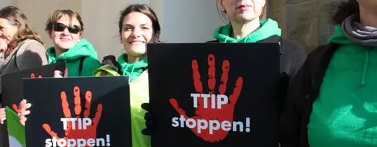 (Foto by Cornelia Reetz | Lizenz: CC BY-SA 2.0) Ein Protest gegen TTIP Mit schildern "TTIP stoppen!" und "Fracking? Nein, danke!" ist zu sehen.