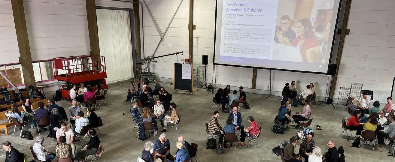 Ein großer Veranstaltungssaal mit vielen Gesprächsgruppen