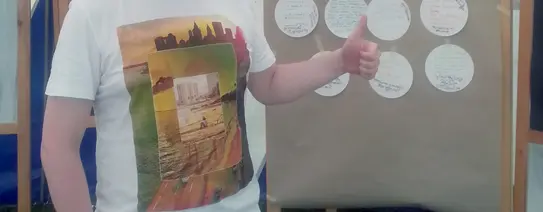 Auf dem Bild steht ein junger Mann vor einem Plakat, wo "Wahlrecht für Alle" drauf steht und noch mehr, was so nicht lesbar ist.