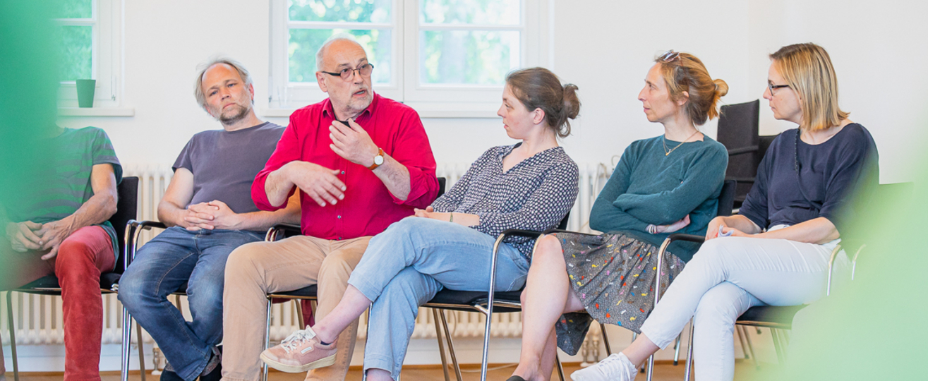 Gesprächskreis aus 5 Personen die nebeneinander sitzen