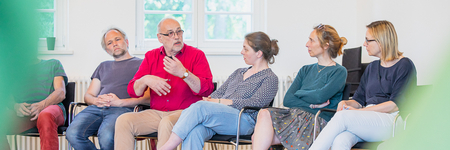 5 Menschen nebeneinander, ein Mann spricht.