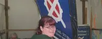 Auf dem Bild ist eine Frau, welche mehrere Plakate für das Volksbegehren trägt.
