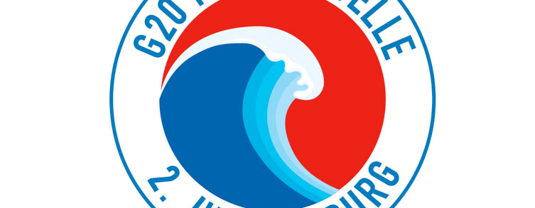 Auf dem Bild ist ein Logo zu sehen, in welchem eine Welle in der Mitte ist. Drumherum steht "G20 Protestwelle 2.Juli Hamburg".