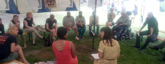 In einem Festzelt sitzen circa 15 Personen und reden miteinander.