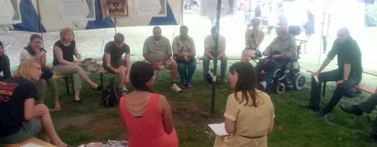 In einem Festzelt sitzen circa 15 Personen und reden miteinander.