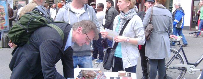 2013-07-08 Duesseldorf-Aktion Ein Informationsstand von Mehr Demokratie in einer Fußgängerzone ist zu sehen und interessierten Menschen, die sich dort unterhalten.