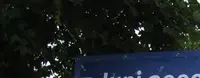 Ein Banner ist zwischen zwei Bäumen aufgehangen, mit den Worten "7.Juni 2009: Europa wählt -- Vaterstetten-stimmt-ab.de". Darunter steht eine Frau.