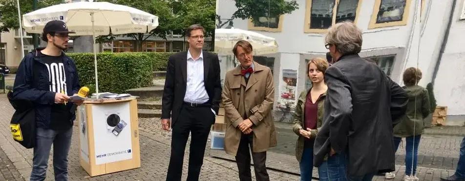 Ein Informationsstand ist zu sehen und Karl Lauterbach ist anwesend.