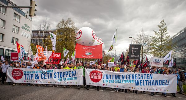 Auf einem Protest sind Transparente mit dem Text "TTIP & CETA STOPPEN!".