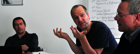 Ein Mann guckt fragend einen anderen Mann an.