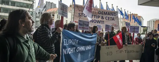 Vor dem Gebäude der EU-Kommission stehen Demonstranten.