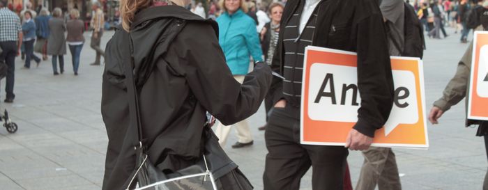 2013-08-30 Verteilen von Material Eine junge Frau verteilt Infomaterial auf der Straße an Passanten.