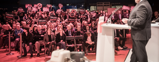 (Foto by Chris Grodotzki/Campact | Lizenz: CC BY-NC 2.0) Sigmar Gabriel hält eine Rede vor Menschen, die gegen TTIP und CETA sind, in einem Saal.