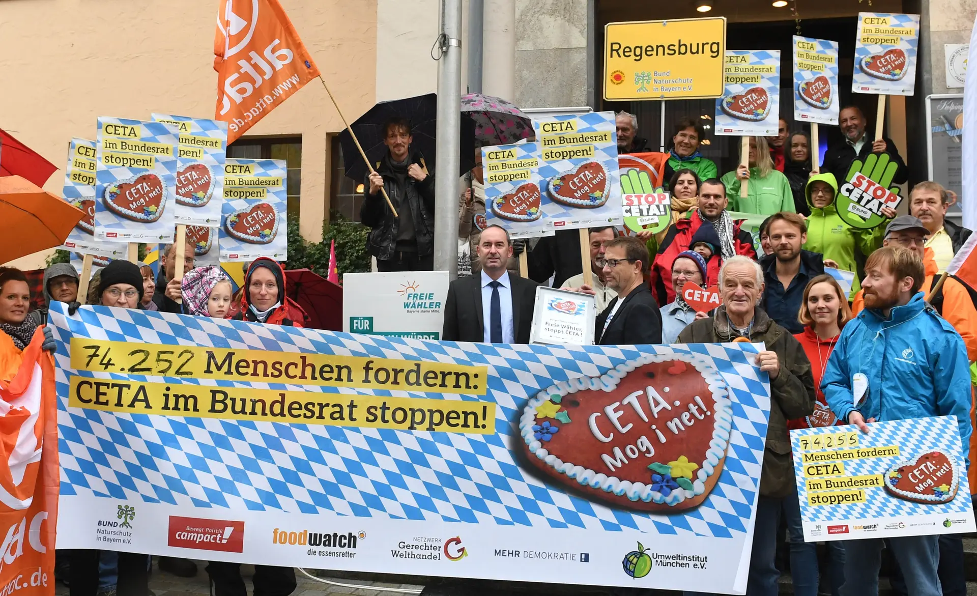 Auf einem Protest sind Menschen mit Transparenten gegen CETA.
