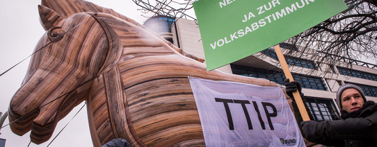 Ein trojanisches Pferd hat auf seiner Flanke ein Plakat mit dem Text "TTIP".