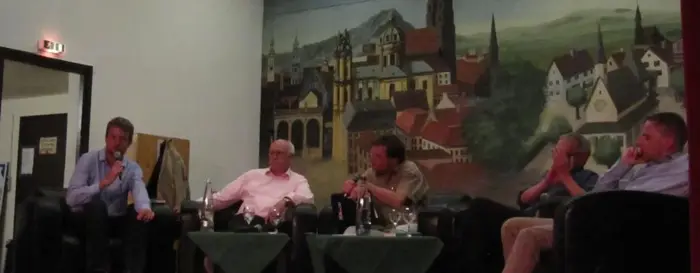 Fünf Menschen sitzen in einem Halbkreis und reden miteinander.