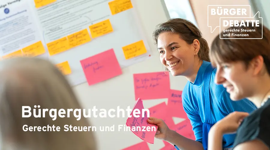 Auf dem Bild ist eine Frau im Fokus vor einer Tafel, welche Karteikarten in der Hand hält. Auf dem Bild steht "Bürgergutachten, Absatz Gerechte Steuern und Finanzen".