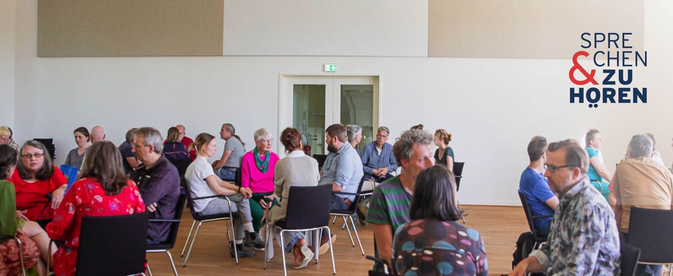 Menschen in Stuhlkreisen (3-4 Personen) in einem hellen Saal, oben rechts das Logo „Sprechen & Zuhören".