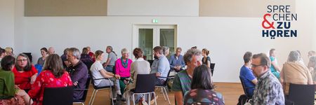 Menschen in Stuhlkreisen (3-4 Personen) in einem hellen Saal, oben rechts das Logo „Sprechen & Zuhören".