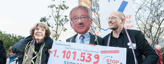Zu sehen ist ein Protestmarsch, gegen TTIP und einem Schild, welches 1.101.539 Unterschriften gegen TTIP gesammelt hat darstellt.