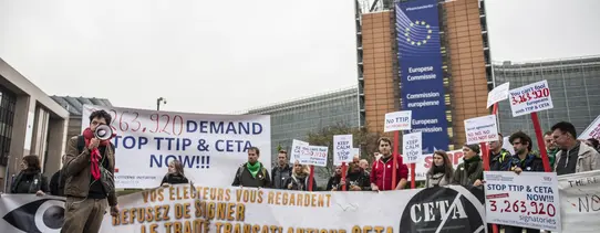 Vor dem Gebäude der EU-Kommission stehen Demonstranten.
