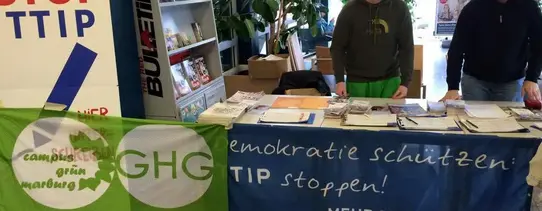 (Sammelaktion an der Uni Marburg | Quelle: Mehr Demokratie e.V. | Lizenz: CC BY-SA 2.0) Ein Infostand von Mehr Demokratie gegen TTIP ist zu sehen.