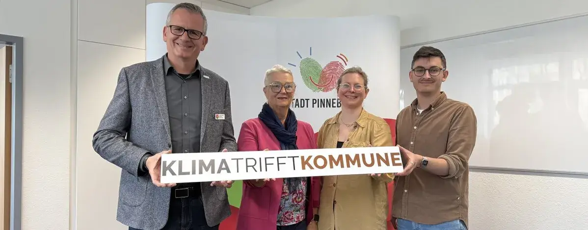 Projektbeteiligte des Pinneberger Klima-Bürgerrates präsentieren gemeinsam das Schild „Klima trifft Kommune“. Zu sehen sind Bürgermeister Thomas Voerste, Bürgervorsteherin Natalina di Racca-Boenigk, Rabea Koss von der Gesellschaft für Klima und Demokratie und Milan Bogojević, Klimaschutzbeauftragter der Stadt Pinneberg