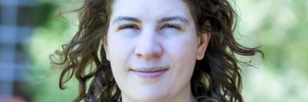 Porträtfoto von Leonora Camner in einem dunkelblauen Oberteil mit Kirsch-Muster