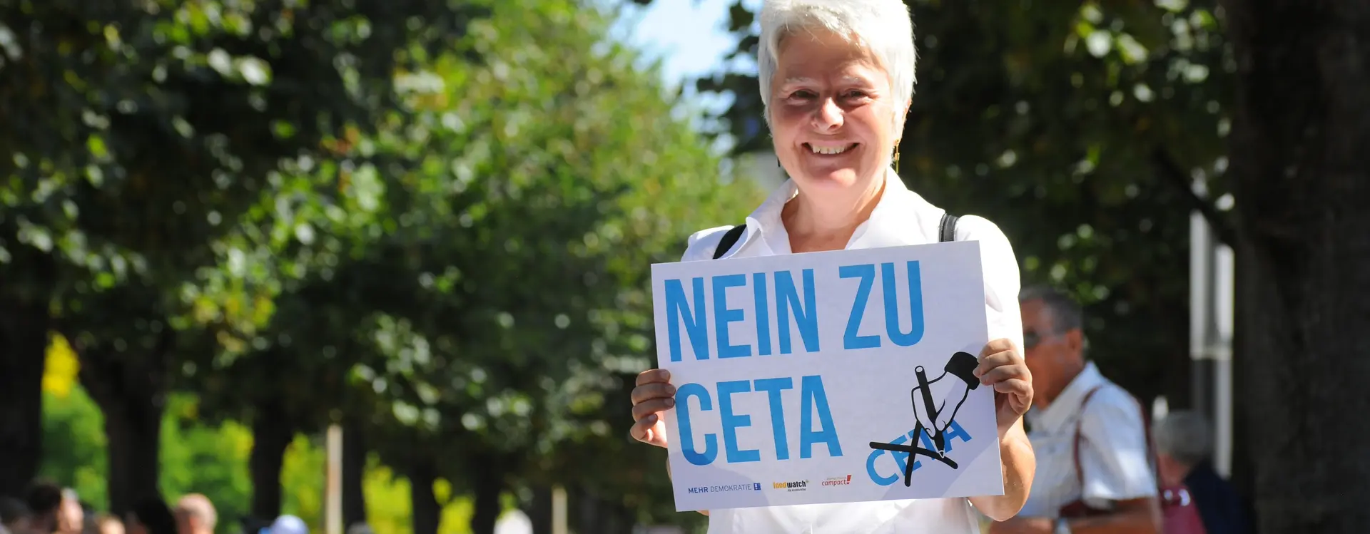 Auf dem Bild ist eine Frau zu sehen, welche ein Plakat hochhält, wo "NEIN ZU CETA" steht.