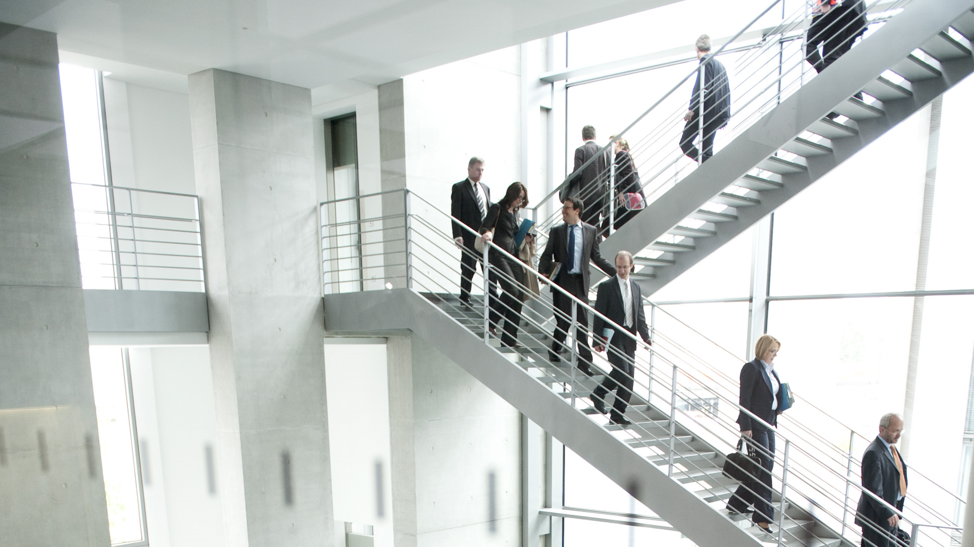 Viele Menschen laufen in einem Anzug eine Treppe herunter.