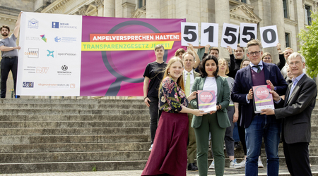 Menschengruppe vor Banner Transparenzgesetz
