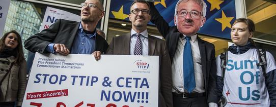 ("Stop TTIP"-Aktion gegen TTIP und CETA vor dem Gebäude der EU-Kommission in Brüssel. | Foto by Alexander Garrido Delgado | Lizenz: CC BY-SA 2.0) Demonstranten mit Plakaten sind vor dem Gebäude der EU-Kommission.