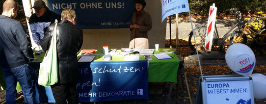 (MD-Infostand | Foto by Charlie Rutz | Lizenz: CC BY-SA 2.0) Auf dem Bild sieht man einen Infostand von Mehr Demokratie.