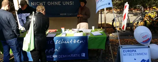 Auf dem Bild sieht man einen Infostand von Mehr Demokratie.