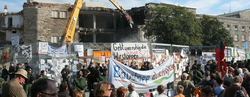 Auf dem Bild ist ein Protest zu sehen, gegen Stuttgart 21 und im Hintergrund ist ein Abrissbagger.
