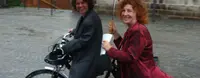 Zwei Frauen sitzen auf einem Fahrrad.