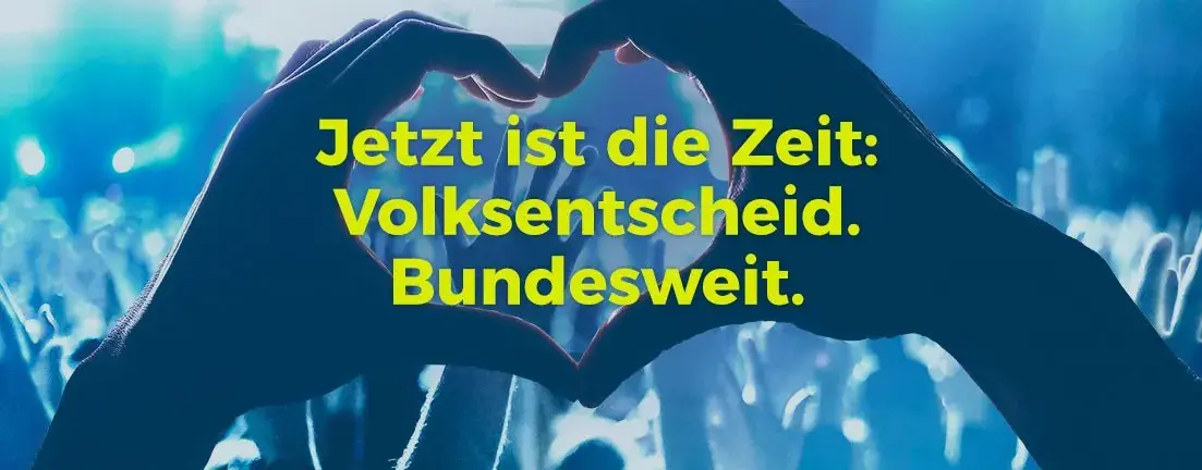Der Fokus auf dem Bild ist auf eine Hände Paar, welches ein Herz formt, darüber steht "Jetzt ist die Zeit: Volksentscheid. Bundesweit".