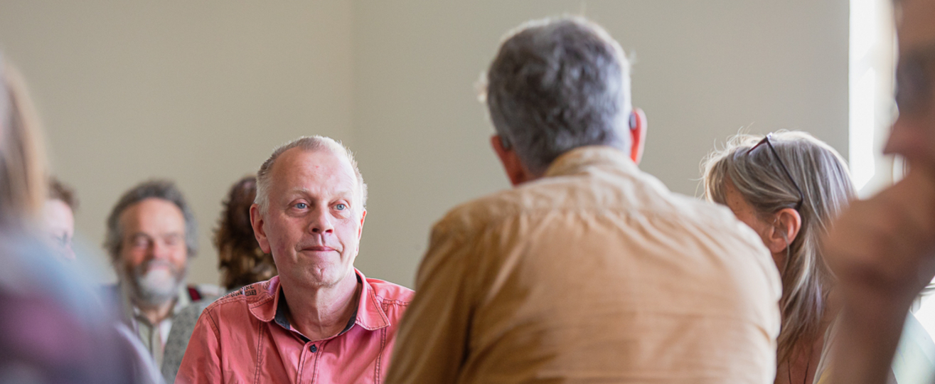 Eine Gesprächsrunde, ein Mann im Fokus.